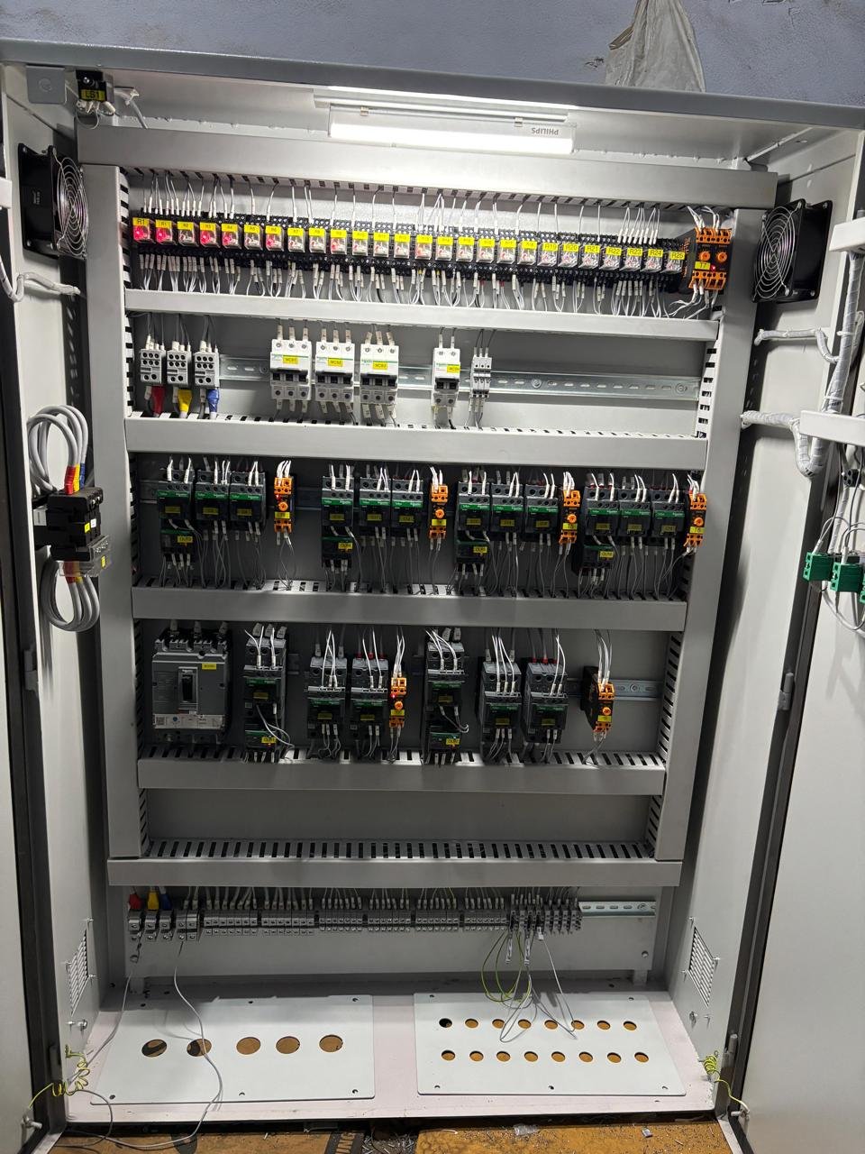 Organized enclosure panel interior with relays and breakers
